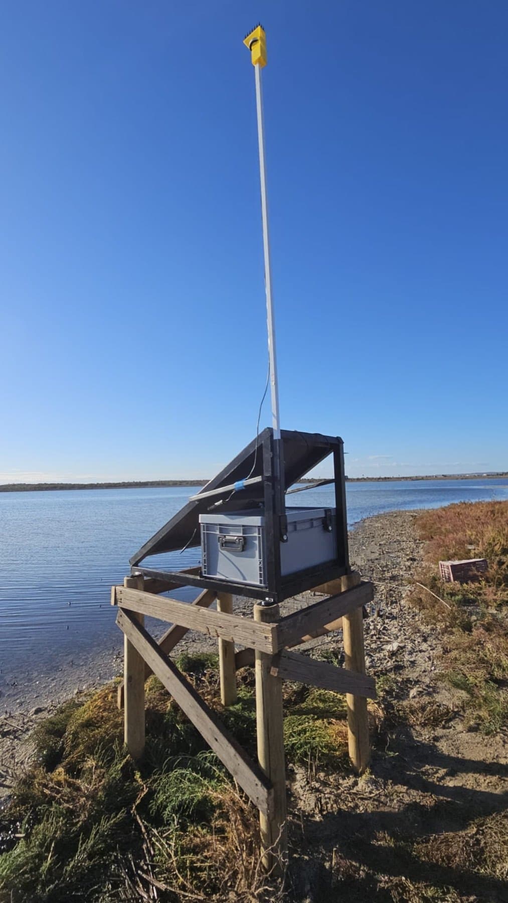 The GNSS-based water level sensor on a wooden stand at the edge of the Torrevieja lagoon