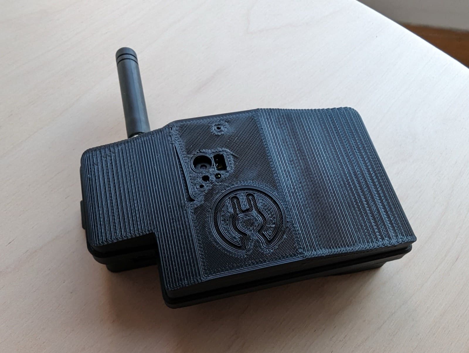 The BODOQUE Dataset Collector on a desk: a black 3D-printed case with a LoRa antenna and a small camera opening