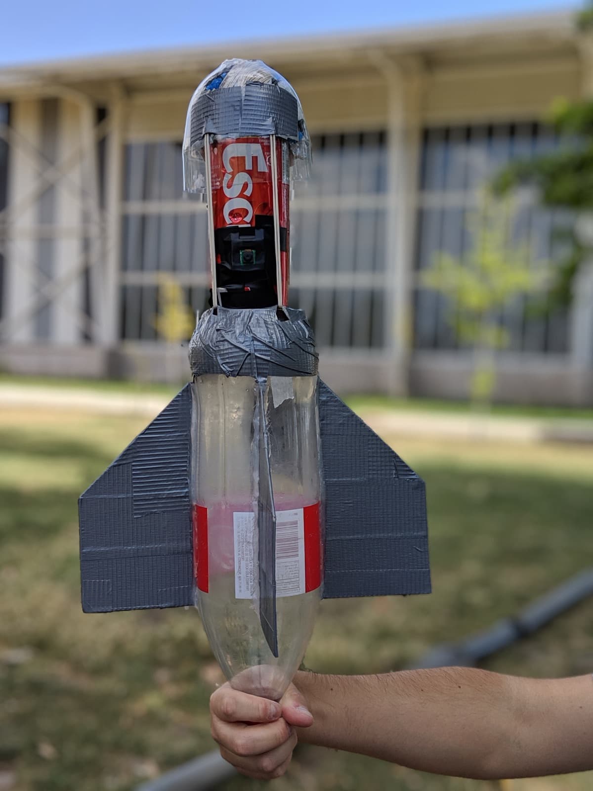 The finished CanSat: a soda-bottle body with cardboard fins, the can holding the Pi and camera up front