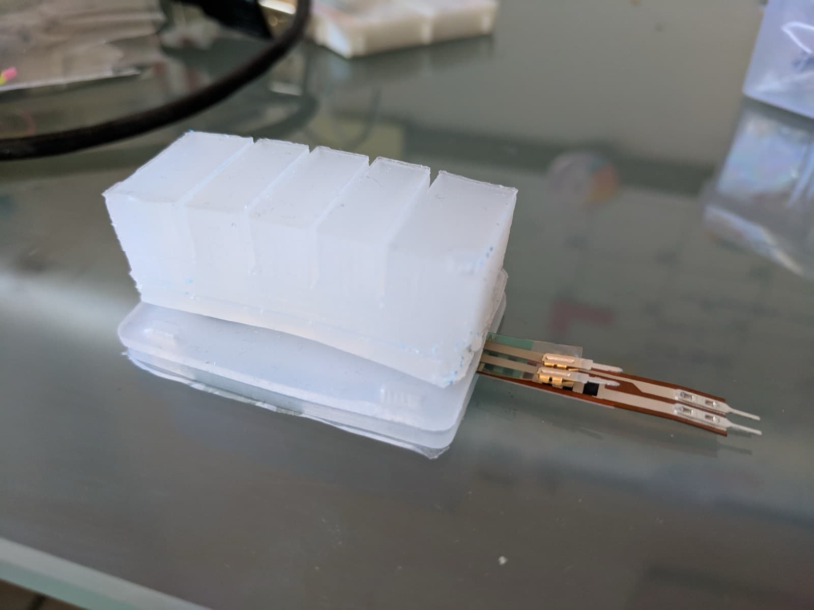 A cast Ecoflex silicone actuator, with a flex sensor and a force sensor embedded along its length